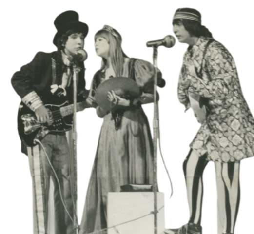 A imagem mostra o grupo musical tropicalista Os Mutantes. São três pessoas cantando em dois microfones